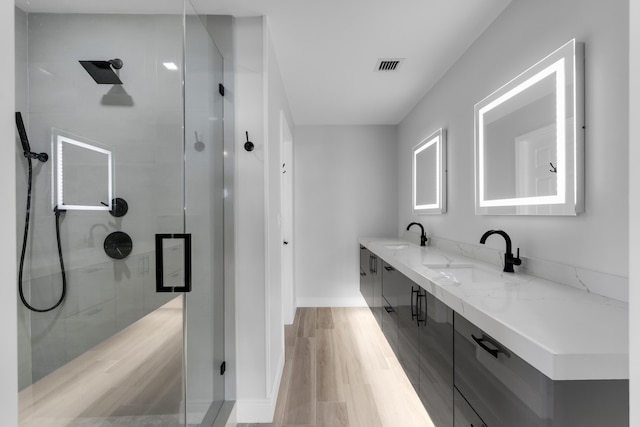 bathroom with a shower with door, vanity, and hardwood / wood-style floors