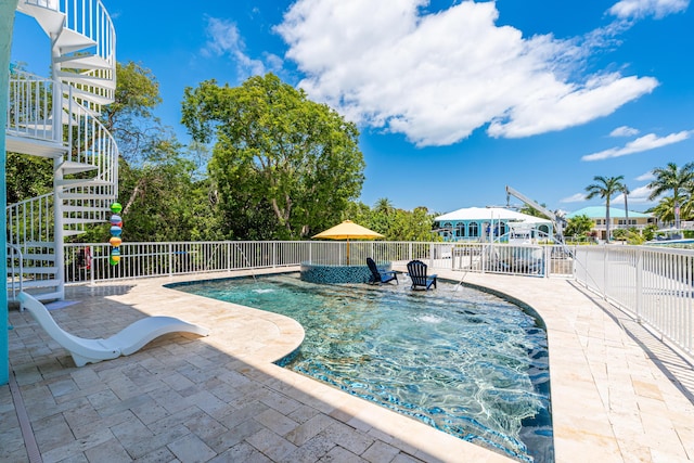 view of swimming pool with pool water feature and a patio area