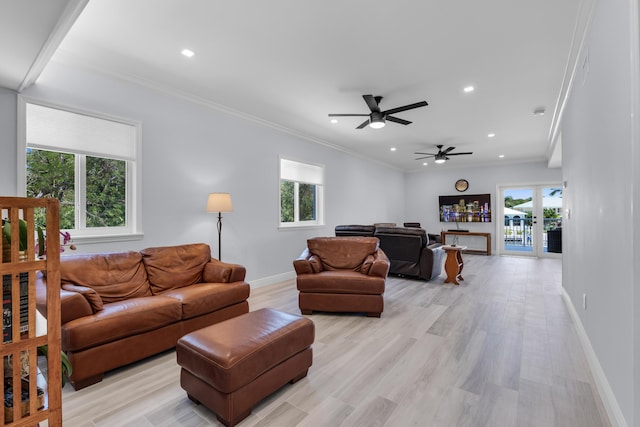 living room featuring ornamental molding, a wealth of natural light, and light hardwood / wood-style flooring