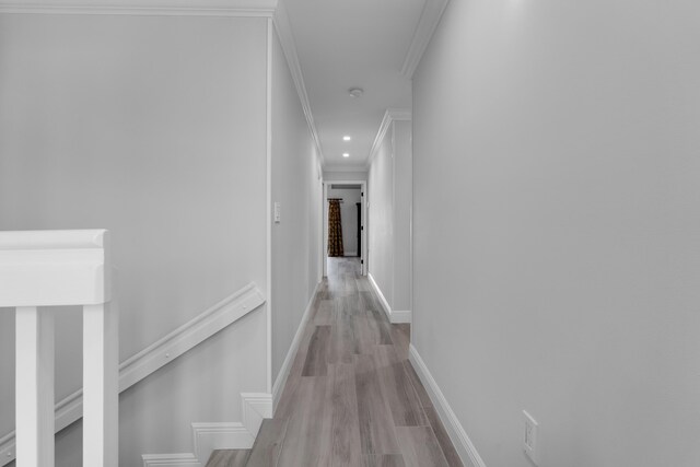 corridor featuring ornamental molding and light hardwood / wood-style flooring