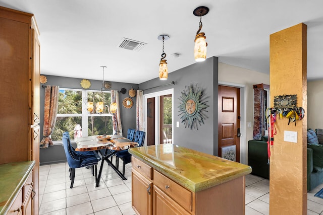 kitchen featuring hanging light fixtures, a center island, and light tile patterned floors