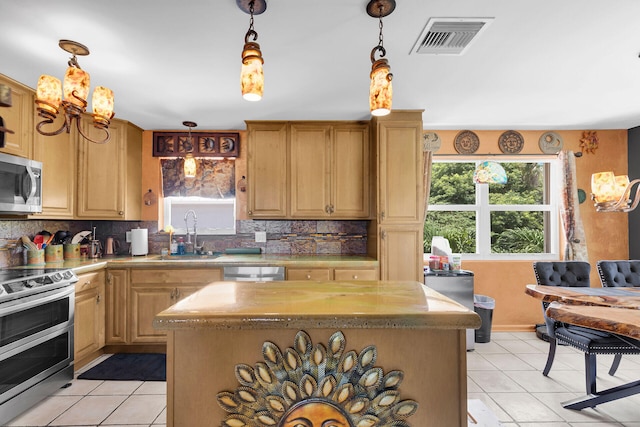 kitchen with sink, decorative backsplash, a center island, and appliances with stainless steel finishes