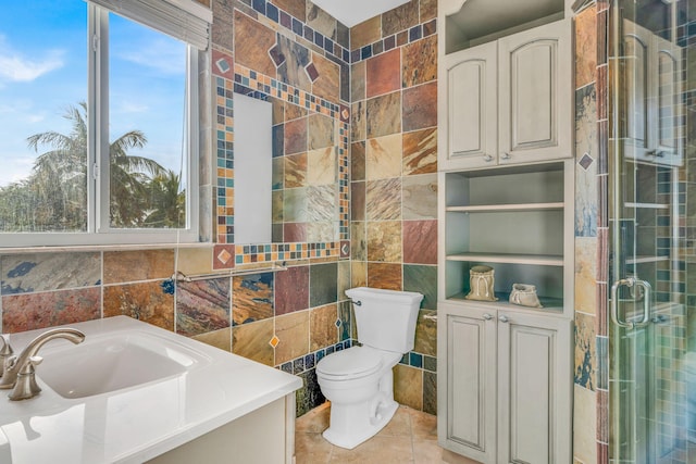 bathroom with tile patterned flooring, toilet, tile walls, and a shower with shower door