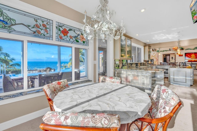 dining room featuring a water view and a notable chandelier