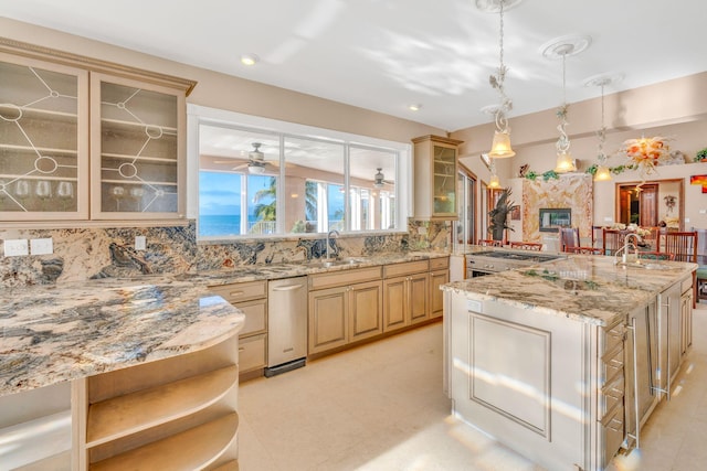 kitchen with light brown cabinetry, sink, decorative backsplash, hanging light fixtures, and light stone countertops