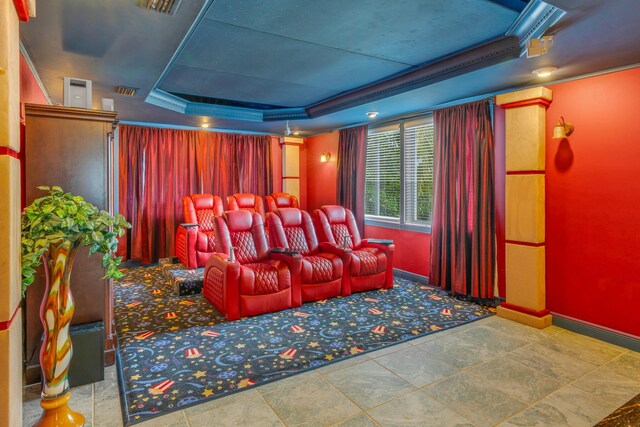 home theater room with a raised ceiling and crown molding