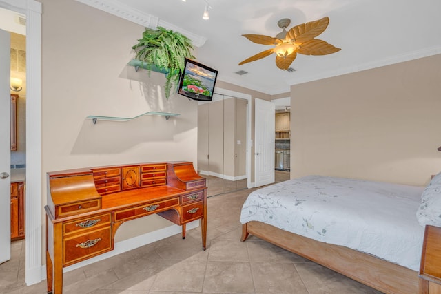 bedroom with ornamental molding, ceiling fan, and a closet