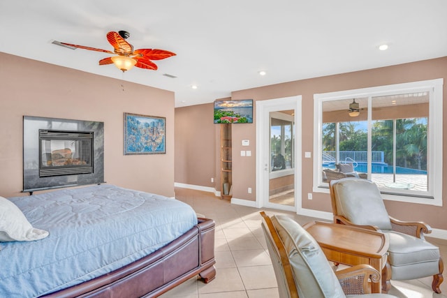 bedroom featuring a premium fireplace, access to outside, ceiling fan, and light tile patterned floors