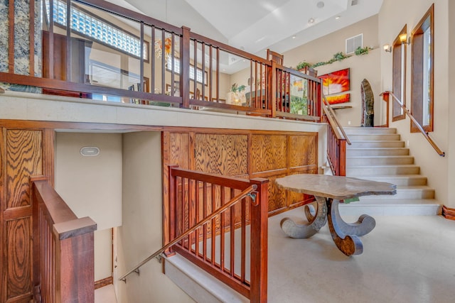 stairs featuring high vaulted ceiling