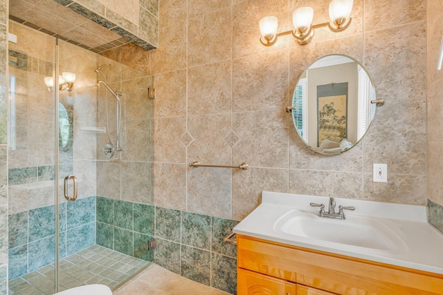 bathroom featuring vanity, tile walls, and a shower with shower door