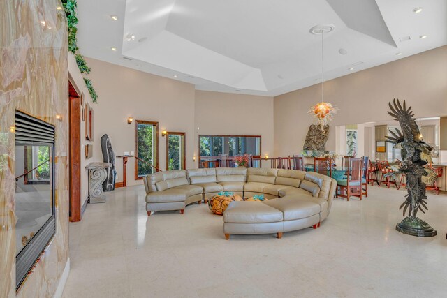 living room featuring a towering ceiling, a tray ceiling, and a wealth of natural light