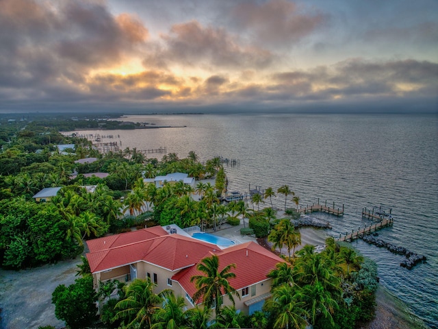 aerial view at dusk featuring a water view