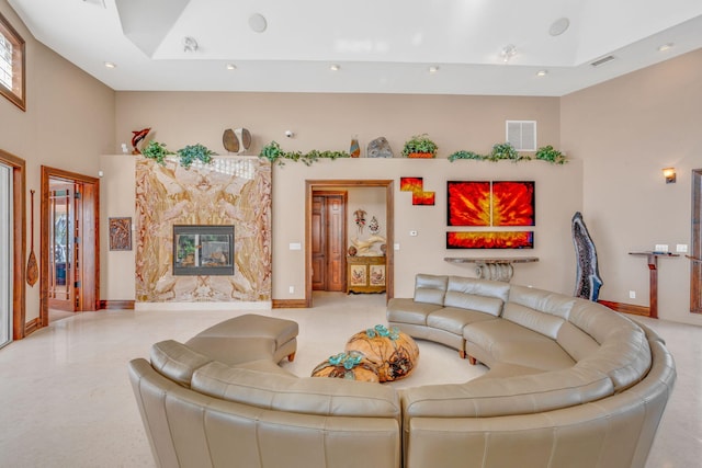 living room featuring a high ceiling and a high end fireplace