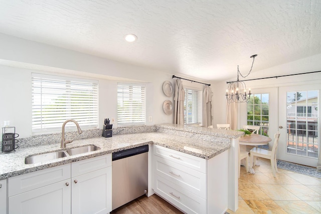 22988 Port Royal Ln, Cudjoe, FL 33042 - kitchen featuring dishwasher, a chandelier, white cabinets, healthy amount of natural light, and a textured ceiling