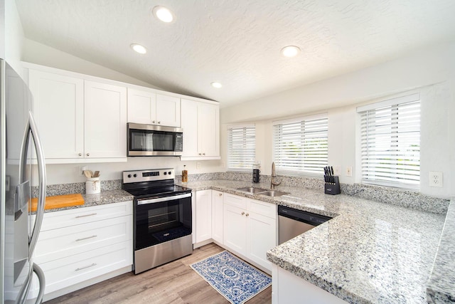 22988 Port Royal Ln, Cudjoe, FL 33042 - kitchen with appliances with stainless steel finishes, lofted ceiling, white cabinetry, light stone counters, and recessed lighting