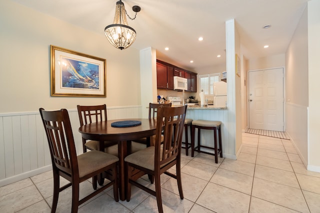 98282 Windward Ave, Key Largo, FL 33037 - dining room with recessed lighting, light tile patterned floors, a notable chandelier, and wainscoting