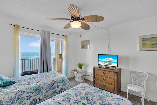 carpeted bedroom with a water view, ceiling fan, access to exterior, and a textured ceiling