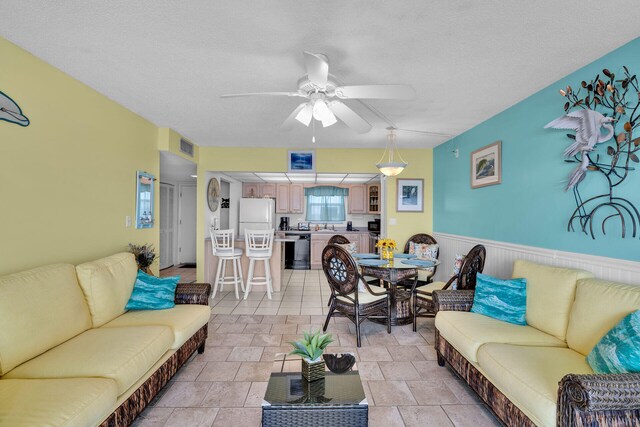 living room featuring a textured ceiling and ceiling fan