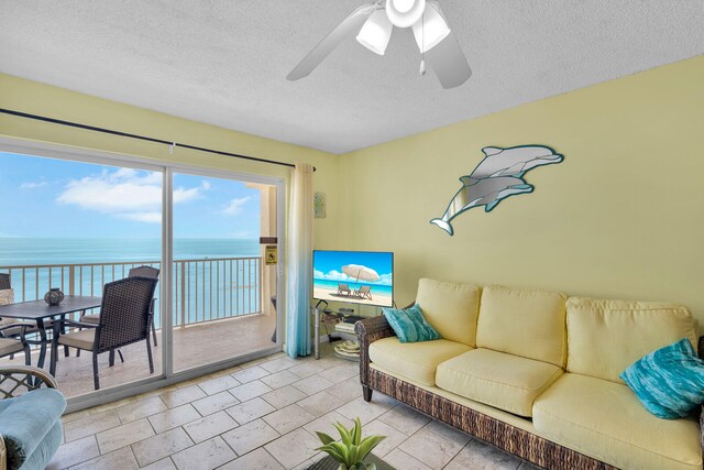 living room with ceiling fan and a textured ceiling