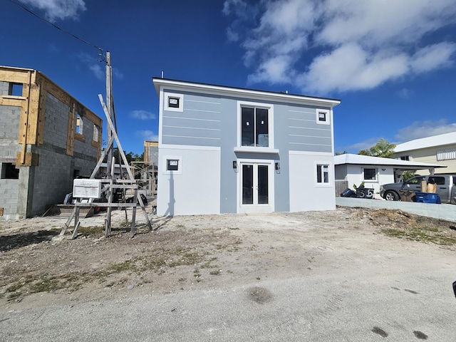 rear view of house featuring stucco siding