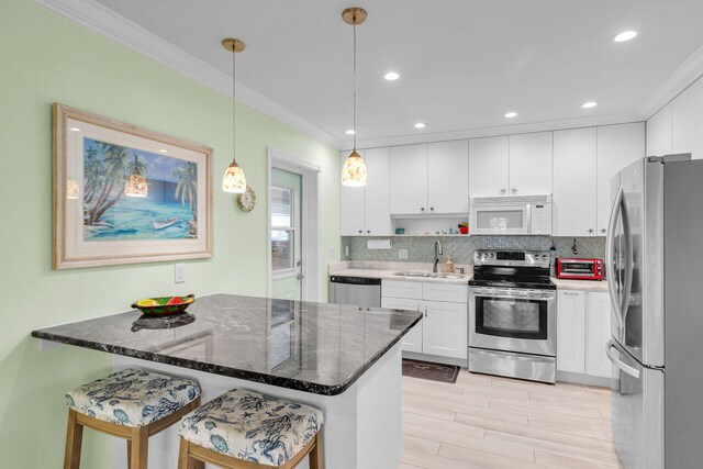 285 Blackbeard Rd, Little Torch, FL 33042 - kitchen featuring pendant lighting, sink, appliances with stainless steel finishes, white cabinetry, and a kitchen breakfast bar