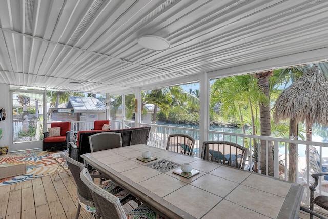 sunroom featuring a water view