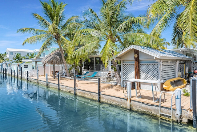 view of pool with a sunroom, a boat dock, and a water view