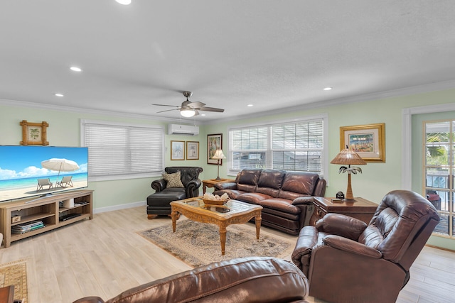 living room with ceiling fan, ornamental molding, a wall mounted AC, and light wood-type flooring