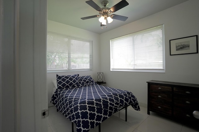 tiled bedroom featuring ceiling fan