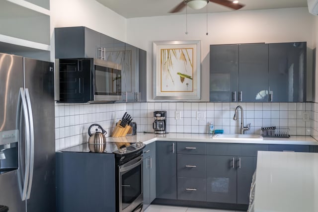 kitchen featuring blue cabinetry, sink, tasteful backsplash, ceiling fan, and stainless steel appliances