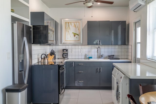 kitchen with sink, tasteful backsplash, a wall mounted air conditioner, black appliances, and washer / dryer