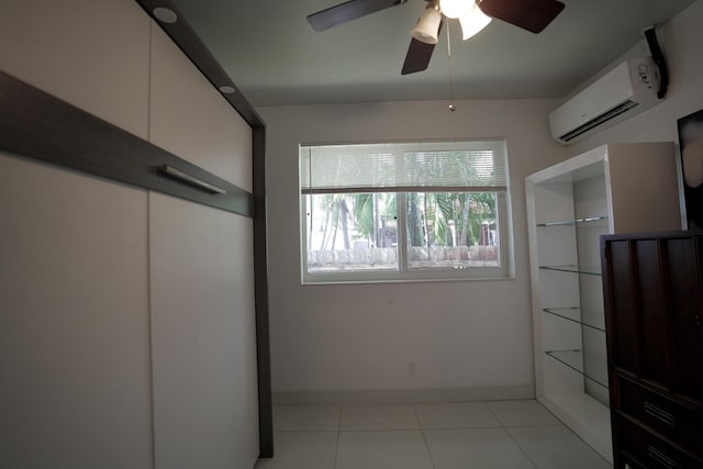 bedroom with ceiling fan, a wall mounted air conditioner, and light tile patterned floors