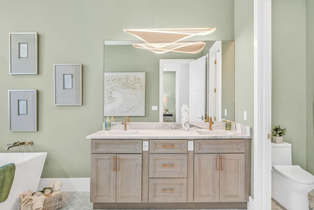 bathroom featuring vanity, toilet, and a tub