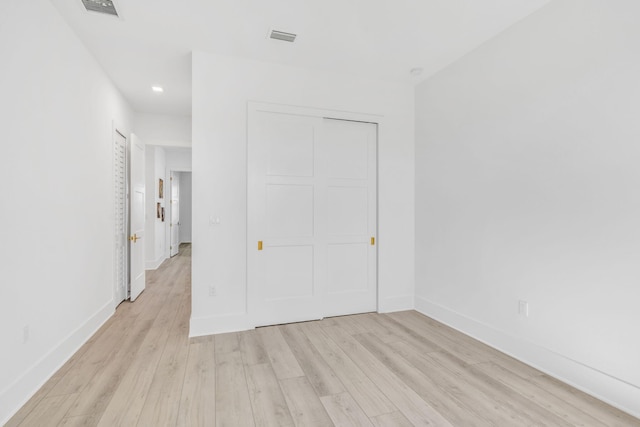 unfurnished bedroom featuring a closet and light wood-type flooring