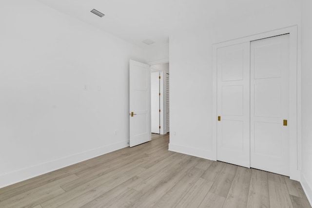 unfurnished bedroom featuring light hardwood / wood-style floors and a closet