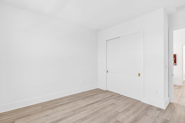 unfurnished bedroom featuring light hardwood / wood-style floors and a closet