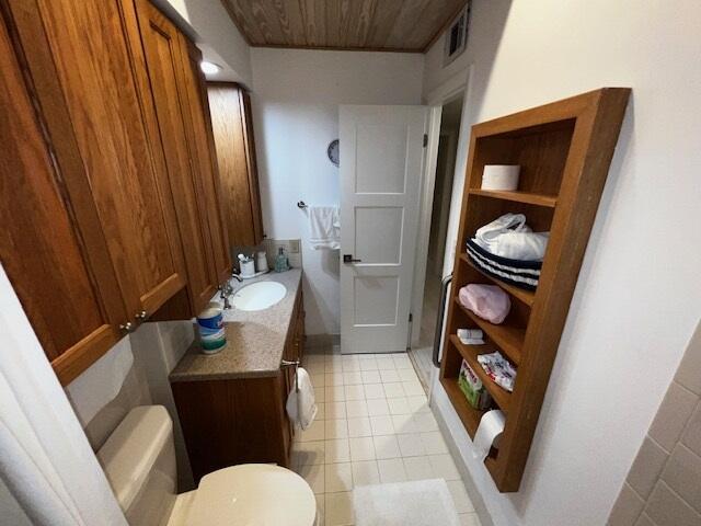 bathroom featuring wood ceiling, vanity, toilet, and tile patterned flooring