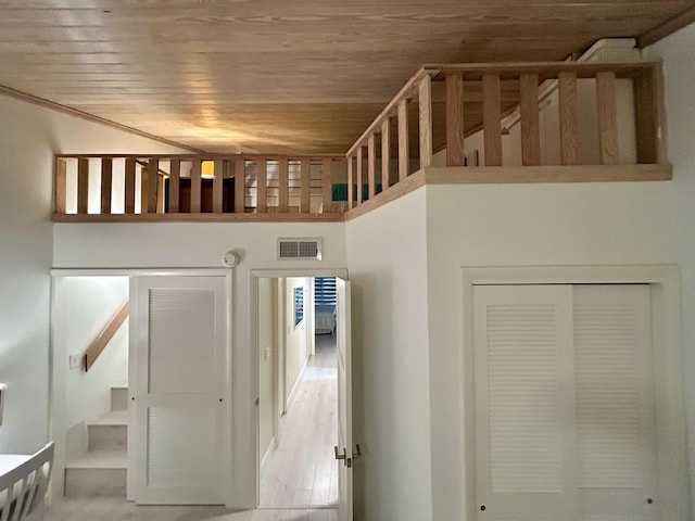 corridor with wood ceiling and a high ceiling