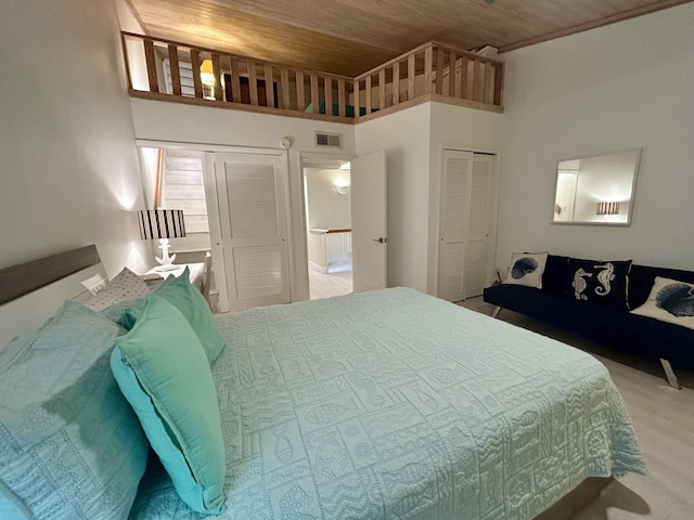 carpeted bedroom with a high ceiling and wooden ceiling