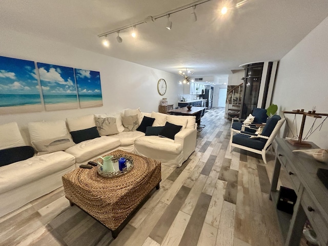 living room featuring a water view, a chandelier, and light wood-type flooring