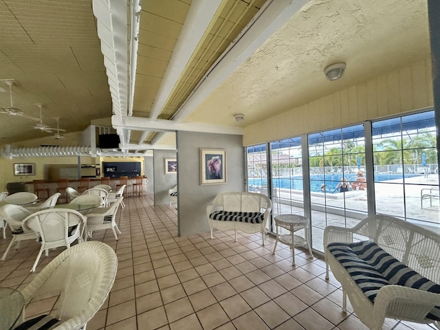 interior space featuring lofted ceiling with beams and tile patterned floors