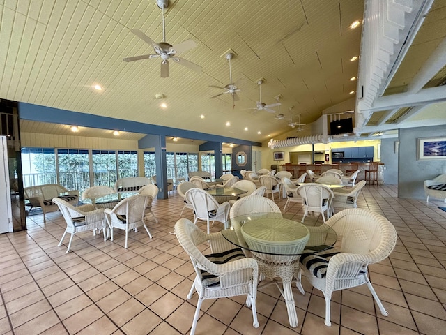 tiled dining space featuring ceiling fan, plenty of natural light, and high vaulted ceiling