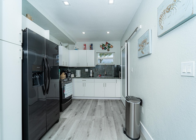25 N Blackwater Ln, Key Largo, FL 33037 - kitchen with black appliances, dark countertops, white cabinetry, light wood-type flooring, and a sink