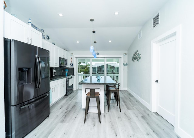 25 N Blackwater Ln, Key Largo, FL 33037 - kitchen featuring refrigerator with ice dispenser, stainless steel electric range oven, white cabinets, a breakfast bar area, and a kitchen island