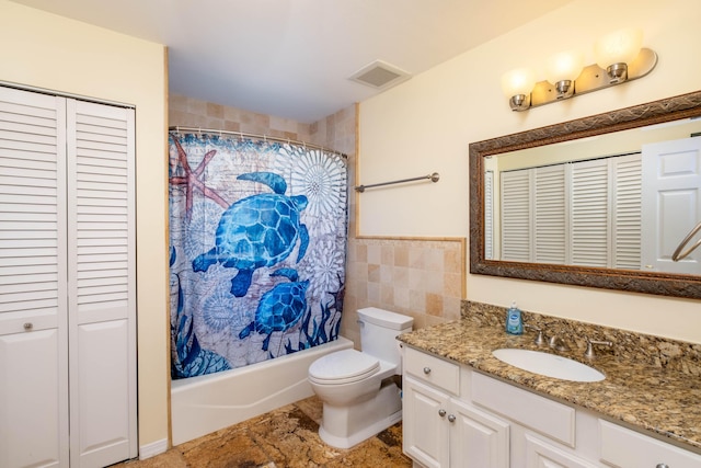 full bathroom with tile walls, vanity, toilet, and shower / tub combo with curtain