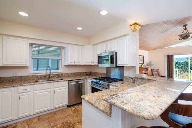 kitchen with sink, a kitchen breakfast bar, kitchen peninsula, and appliances with stainless steel finishes