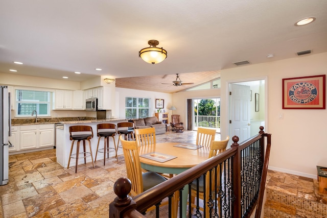 dining space with sink, vaulted ceiling, and ceiling fan