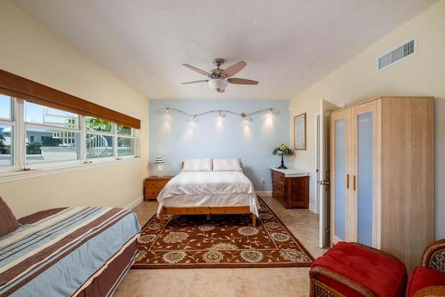 tiled bedroom featuring a textured ceiling and ceiling fan