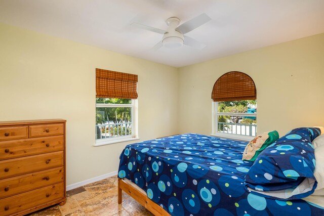 bedroom featuring multiple windows and ceiling fan