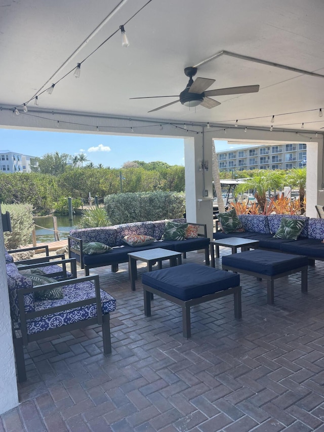 view of patio / terrace featuring a water view, ceiling fan, and an outdoor hangout area